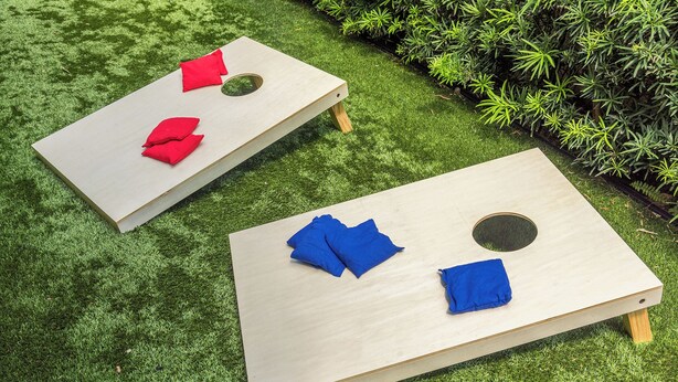 Two wooden tables with cushions on a grassy surface. - Lux WPB Oasis with Heated Pool/Spa + GameRoom – Sleeps 12! (West Palm Beach)
