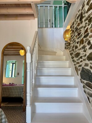 A staircase with white steps and a stone wall.