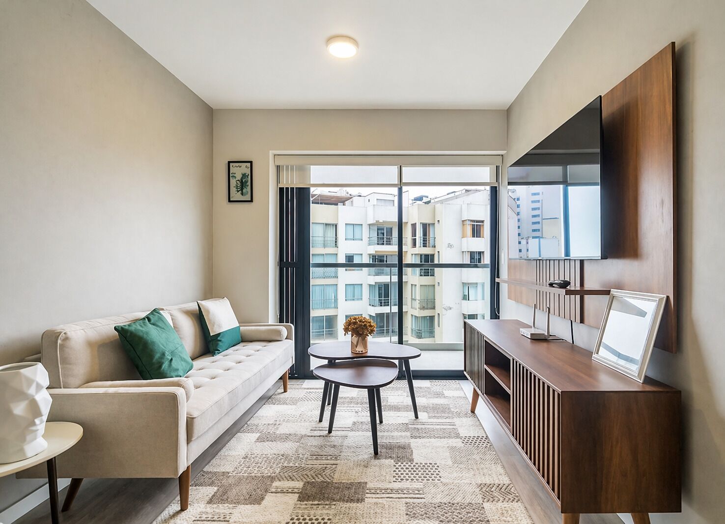 A modern living room with a sofa, a coffee table, and a TV mounted on the wall.