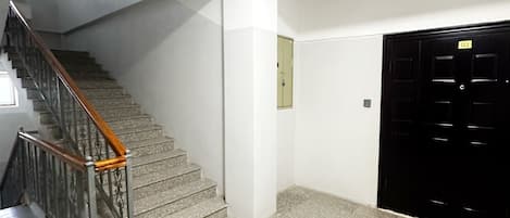 A staircase with metal railings and a carpeted floor leading to a door marked with the number 03.
