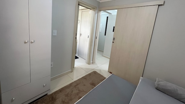 A room with a bed, wardrobe, and a door leading to another room. - Family apartment with great comfort and a great location in Toledo, Paraná. (Toledo)