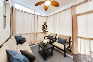 Ein Zimmer mit einer Sofagarnitur, einem Couchtisch und einer Zimmerpflanze.