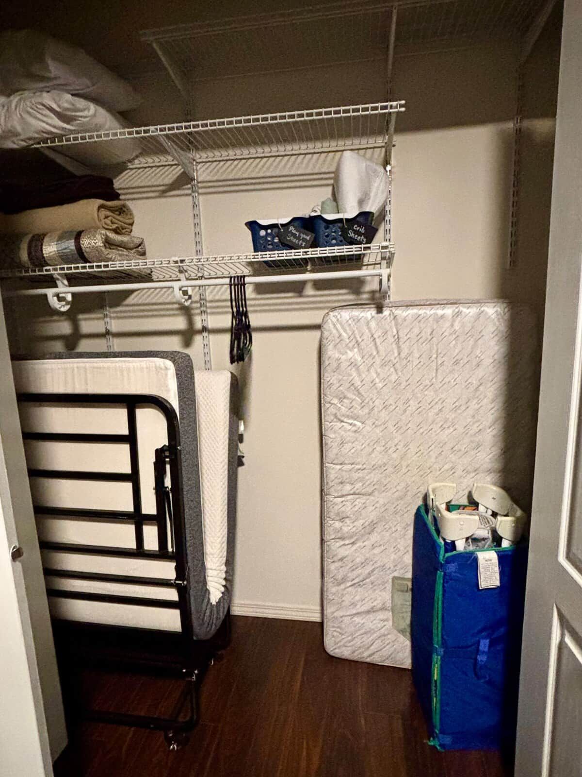 Un armario con estantes, un colchón y una cama plegable.