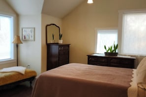 Un dormitorio con cama, cómoda y plantas en macetas.