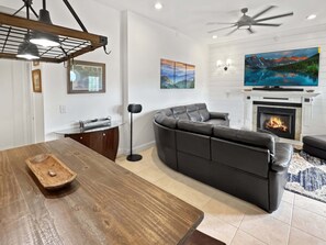 Ein modernes Wohnzimmer mit einer Eckcouch, einem Kamin und einem Fernseher.
