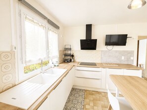 A modern kitchen with a sink, countertop, and a black range hood. - Les Glaieuls by Interhome (Deauville-Trouville)