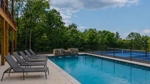 A swimming pool with lounge chairs and a stone waterfall feature. - Pickleball Court, Heated Pool, Mtn Views, luxury finishes, close to town (Blue Ridge)