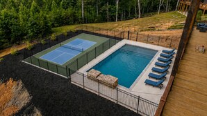 A pool with a tennis court and lounge chairs. - Pickleball Court, Heated Pool, Mtn Views, luxury finishes, close to town (Blue Ridge)