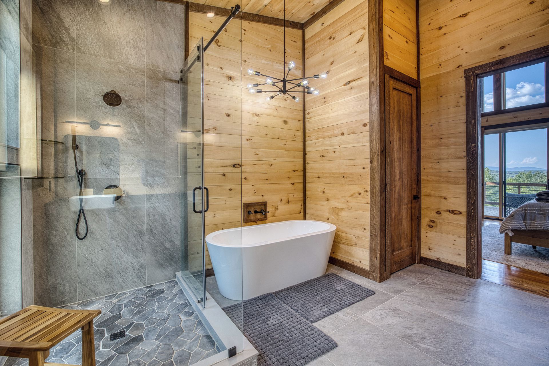 A modern bathroom with a glass-enclosed shower, a freestanding bathtub, and a wooden ceiling.