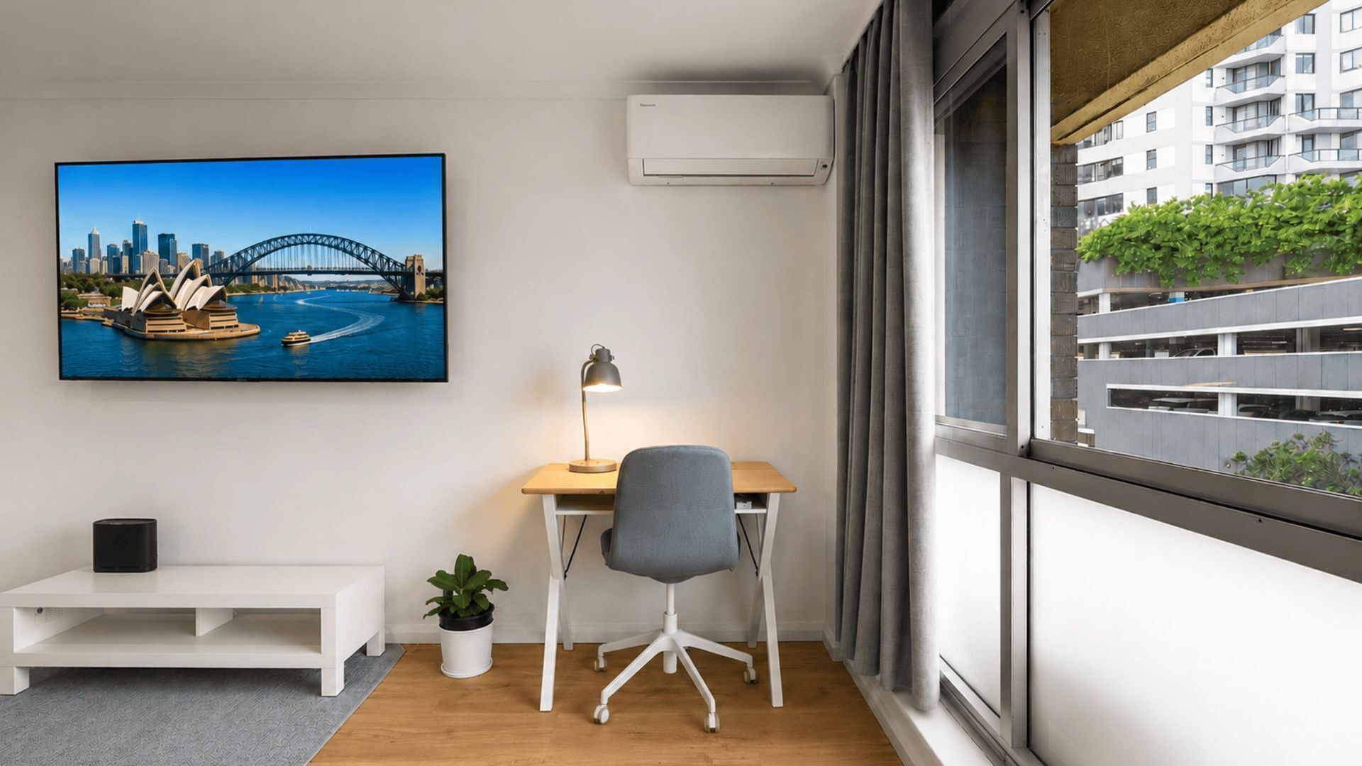 A modern office space with a desk, chair, and a large window.