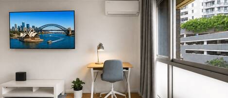 A modern office space with a desk, chair, and a large window.