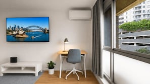 A modern office space with a desk, chair, and a large window. - Newland Heights Rooftop Pool & Bondi Living (Bondi Junction)