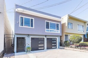 Ein zweistöckiges Wohnhaus mit Garage, kleinem Garten und Metallzaun.
