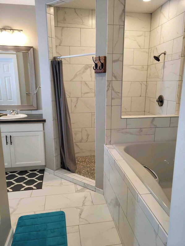 A bathroom with a shower, a bathtub, a sink, and a mirror. - CO Mountain getaway (Kremmling)