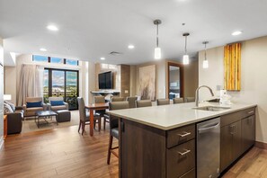 A modern kitchen with a large island, built-in appliances, and a dining area with a view. - Grand Colorado Peak 8 | Spacious 4-Bedroom (Two Full 2-Bedroom Villas) (Breckenridge)