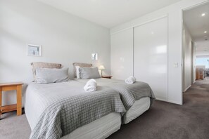 A bedroom with a bed, a bedside table, a lamp, and a wardrobe.