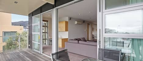 A modern apartment with a balcony, a sofa, and a dining area.