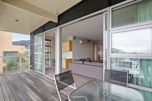 A modern apartment with a balcony, a sofa, and a dining area. - Penthouse Apartment in the heart of Nelson (Nelson)