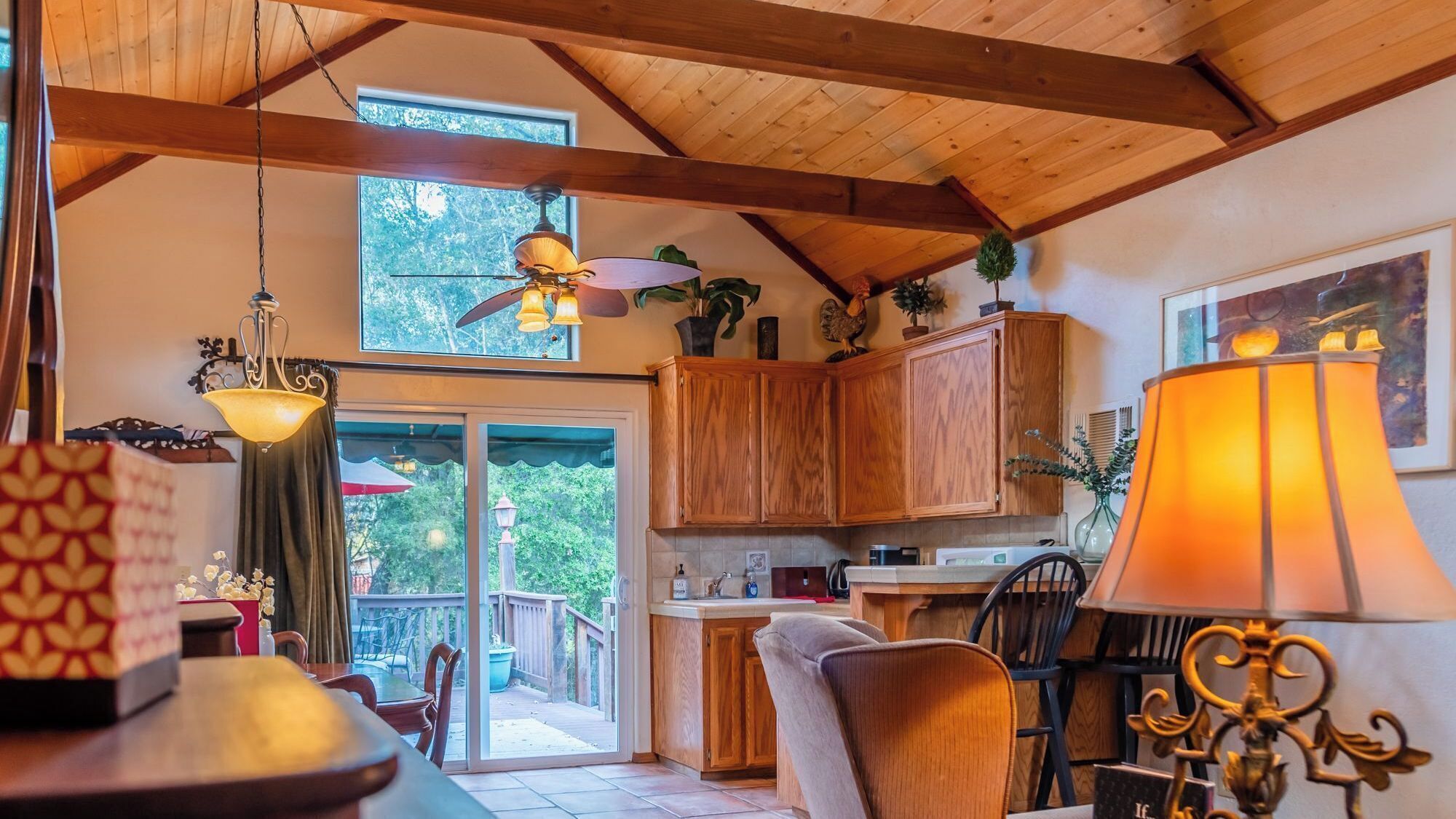 Eine gemütliche Küche mit Holzschränken, ein Essbereich mit Tisch und Stühlen sowie ein großes Fenster mit Blick auf Grünflächen.