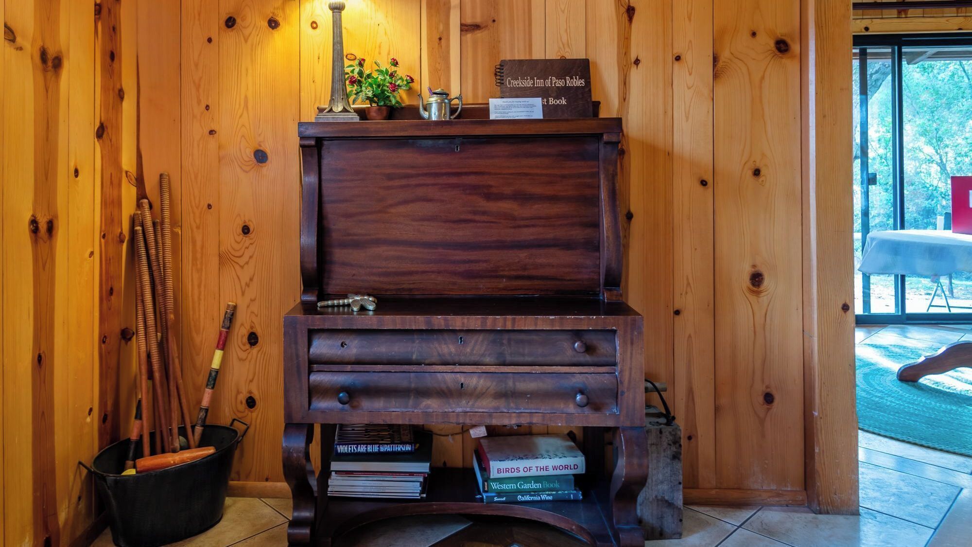 A wooden desk with a book titled 'Creekside Inn of Paso Robles' and a sign indicating it's the first book.