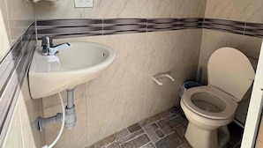 Ein Badezimmer mit Waschbecken, Toilette und Fliesenboden.