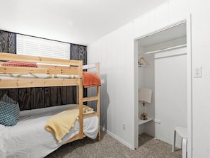 A bunk bed with a wooden ladder, a bedside table with a lamp, and a closet with a hanging rack. - Pet-Friendly 4BR - Free Parking - Utah Retreat (West Valley City)