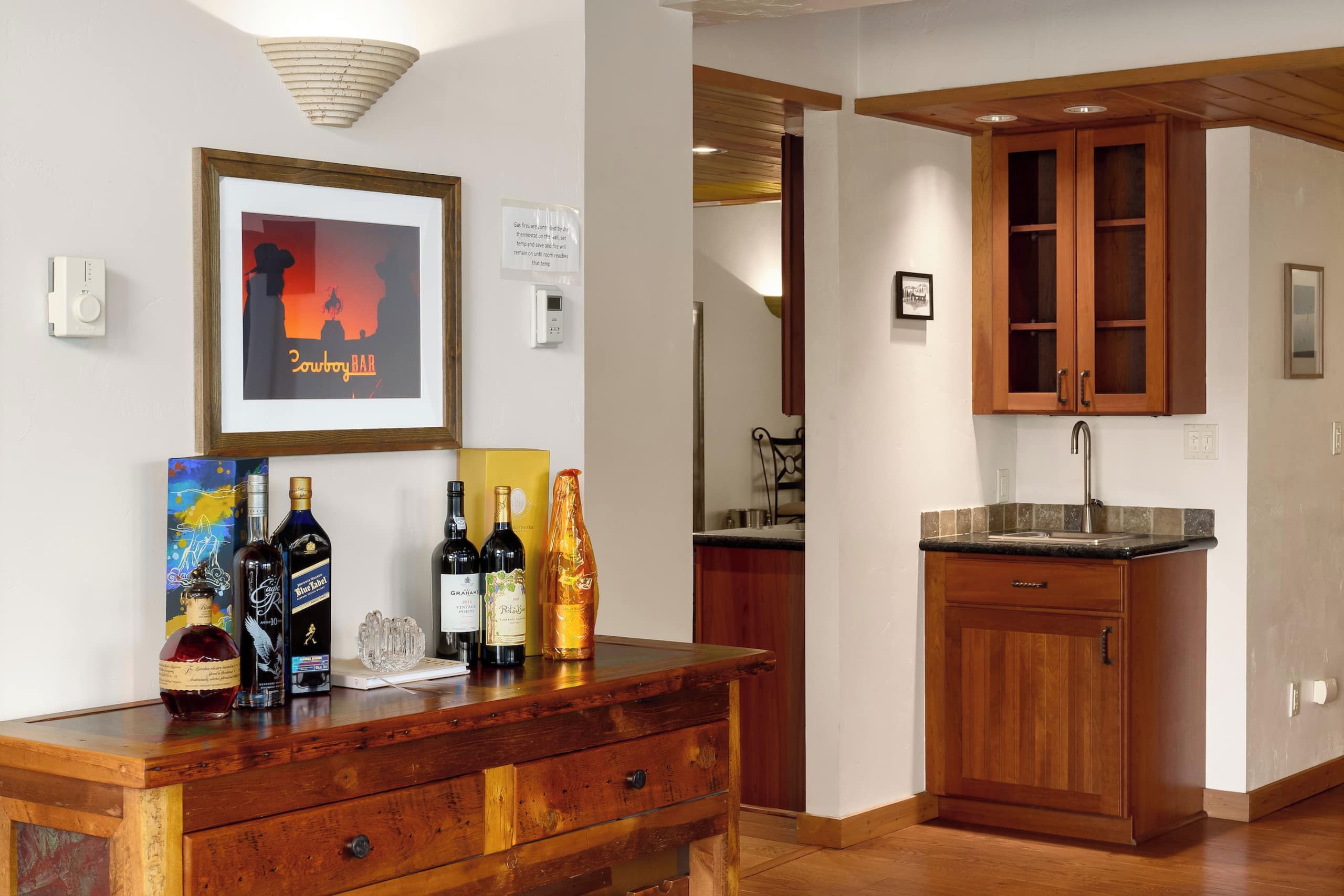 Una cocina bien iluminada con armarios de madera, una encimera y un cuadro en la pared.