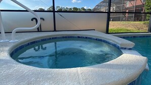A hot tub with a clear view of the sky and a building in the background. - Charming residence with a private pool located in proximity to Disney World (Kissimmee)