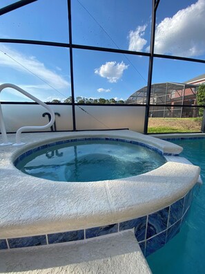 A hot tub with a clear view of the sky and a building in the background. - Charming residence with a private pool located in proximity to Disney World (Kissimmee)