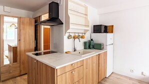 Une cuisine moderne avec des meubles en bois, un four à micro-ondes encastré et une machine à café.
