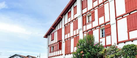 A traditional half-timbered building with multiple windows and a clear sky.