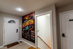 Ein Flur mit einer Tür links, einer Tür rechts und einer Wand mit einem farbenfrohen Plakat.
