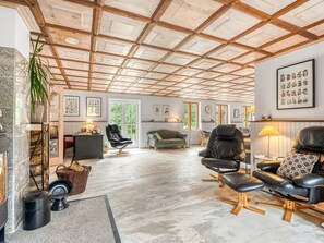 Uma sala de estar ampla com pé direito alto, assentos confortáveis e lareira.