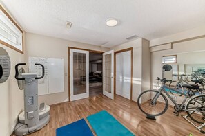 A gym with exercise equipment, a bicycle, and a mirrored wall. - Luxury home in Calgary NW (Calgary)