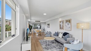 A modern living room with a sofa, coffee table, and artwork on the wall. - Azure 25 - Wake up to the Ocean (The Entrance)