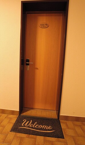 A wooden door with a 'Welcome' mat at the entrance. - The Art of Alpine Living, Wallis 1097 (Wallis)