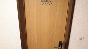 Eine Holztür mit Fußmatte und einem Schild, auf dem 'Bärgliibi' steht.