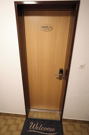 A wooden door with a 'Welcome' mat and a sign that reads 'Bärgliibi.' - Alpine Calm with Unforgettable Views 1099 (Wallis)