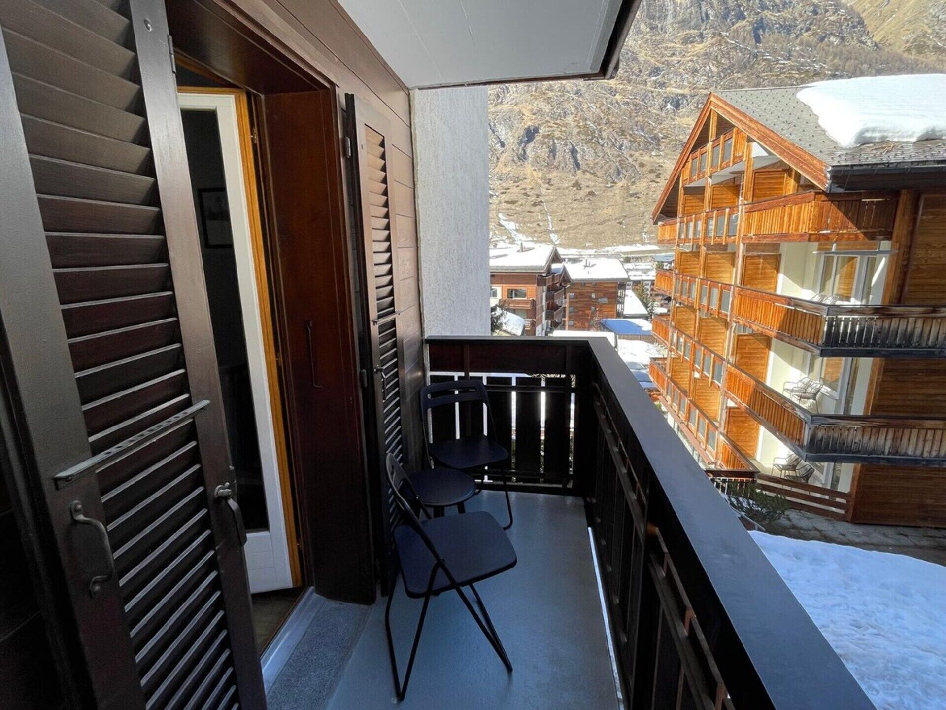 A balcony with a view of a mountain and wooden buildings.
