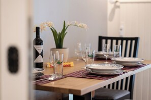 A dining table set with plates, glasses, a wine bottle, and a potted plant. - A Luxurious Retreat Above Zermatt 1100 (Wallis)