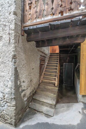 A narrow stone staircase leading to a wooden door. - Elegant Escape in the Swiss Alps 1101 (Wallis)