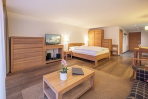 Ein Hotelzimmer mit einem Bett, einem Holztisch, einem Fernseher und einem Kleiderschrank.