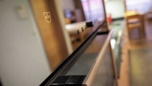 En gang med træloft og et skilt med logoet 'V ZUG'.