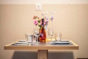 A dining table with four glasses and a vase of flowers. - Where Mountain Mornings Feel Extraordinary 1094 (Wallis)
