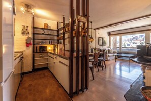 Une cuisine moderne agrémentée d’éléments en bois, un coin repas offrant une belle vue et un espace salon confortable.