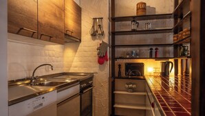 A compact kitchen with a stainless steel sink, a stove, and a tiled backsplash. - Luxury  in Perfect Location, Valais  1410 (Valais)
