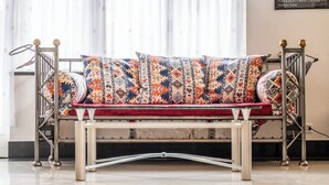 A modern metal sofa with patterned cushions in a well-lit room with a tiled floor. - Alpine Serenity with Iconic Mountain Views 1090 (Wallis)