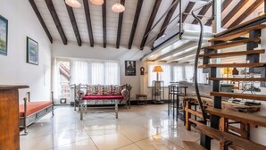 A spacious living area with a wooden bench, a sofa, and a dining table. - Alpine Serenity with Iconic Mountain Views 1090 (Wallis)