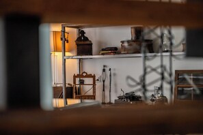 A room with a wooden chair, a desk with a typewriter, and shelves with various items including books and a lamp. - Alpine Serenity with Iconic Mountain Views 1090 (Wallis)