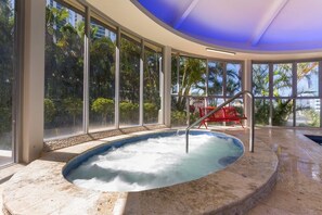 A hot tub with a view of palm trees and a red chair. - Ocean View 3BR Walk to Cavill Ave and the Beach (Surfers Paradise)
